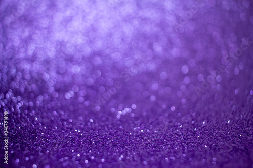 Sparkling purple glitter texture background with defocused bokeh