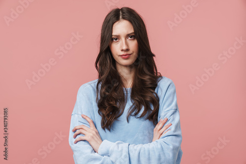 Image of displeased woman frowning and standing with arms crossed
