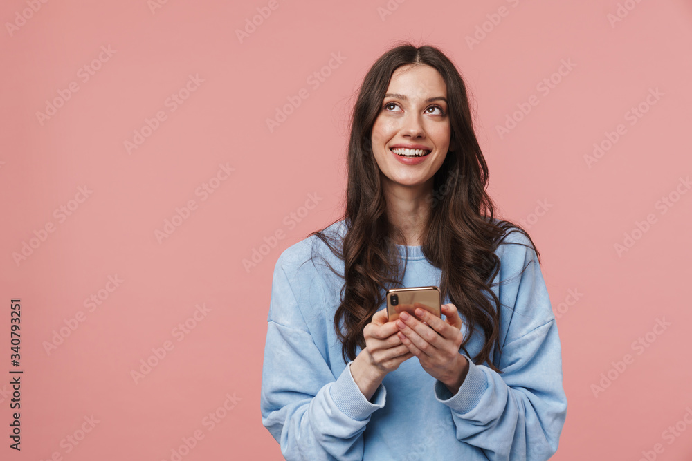 Image of joyful young woman looking upward and using cellphone Image of joyful young woman looking upward and using cellphone