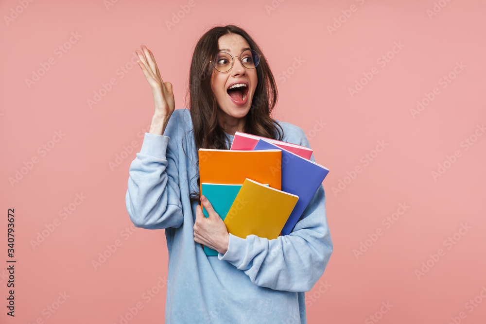 Image of attractive young student girl smiling and holding exercise books Image of attractive young student girl smiling and holding exercise books