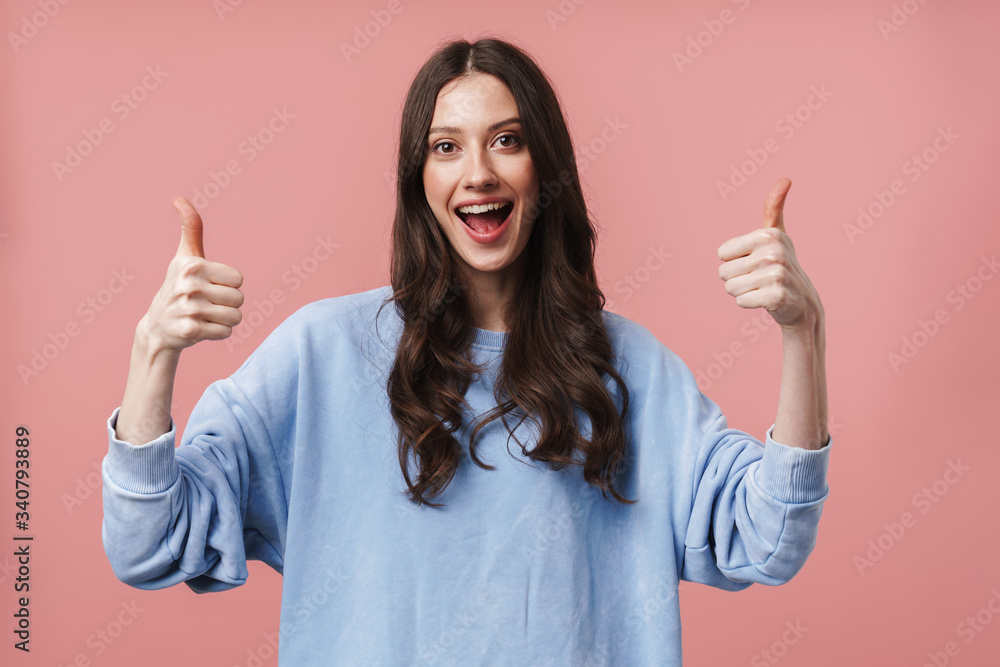 Image of attractive young woman smiling and gesturing thumbs up Image of attractive young woman smiling and gesturing thumbs up