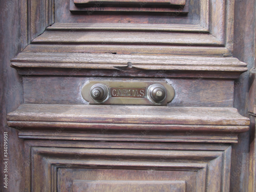 Old hardware for letters, mail box, on antique natural wood door. Background for e-mail web with natural texture and historical iron object illuminated by sunlight. Old hardware for letters, mail box, on antique natural wood door. Background for e-mail web with natural texture and historical iron object illuminated by sunlight.