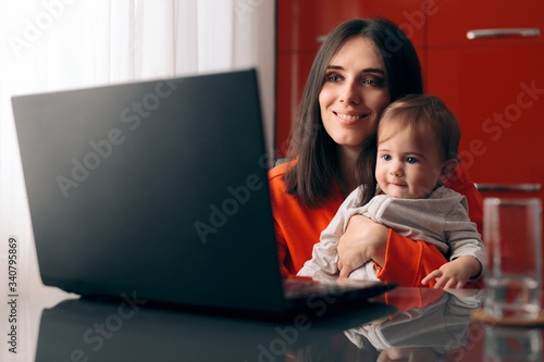 Happy Mother and Baby Watching Cartoon on the Laptop