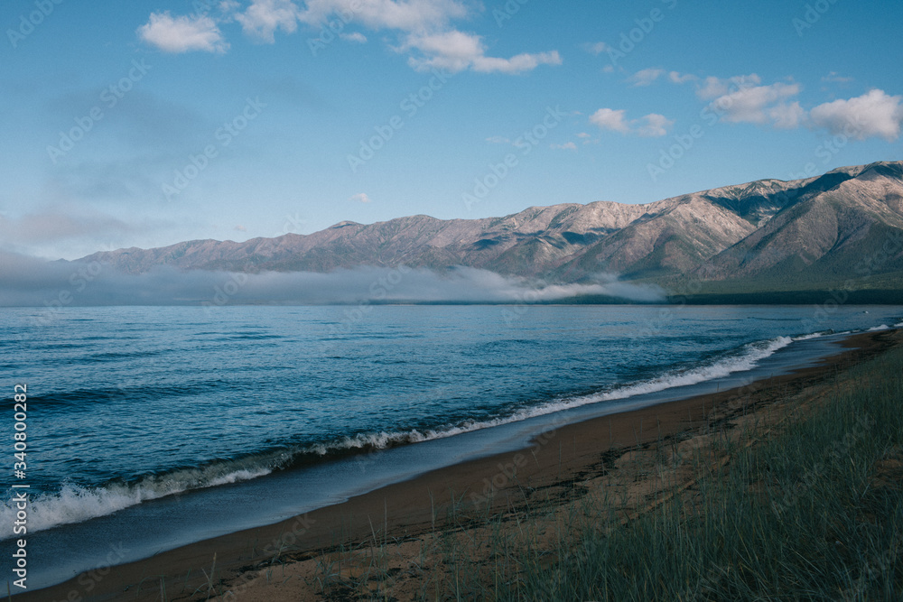 A body of water with a mountain in the background