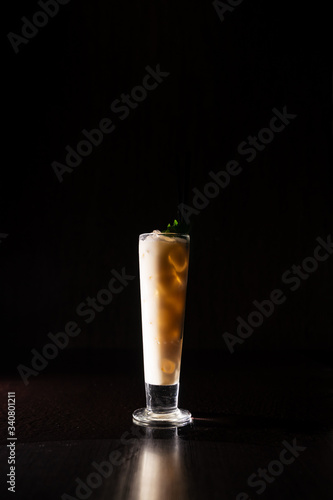 creamy alcohol cocktail with mint leaves on a neutral black background