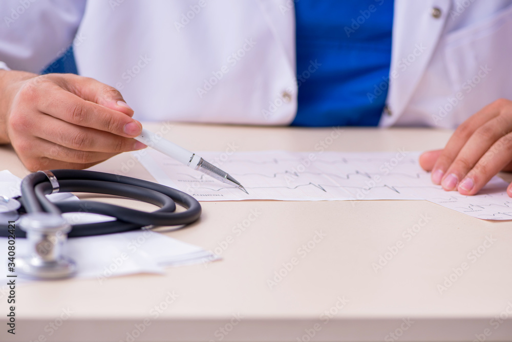 Young male doctor cardiologist working in the clinic Young male doctor cardiologist working in the clinic