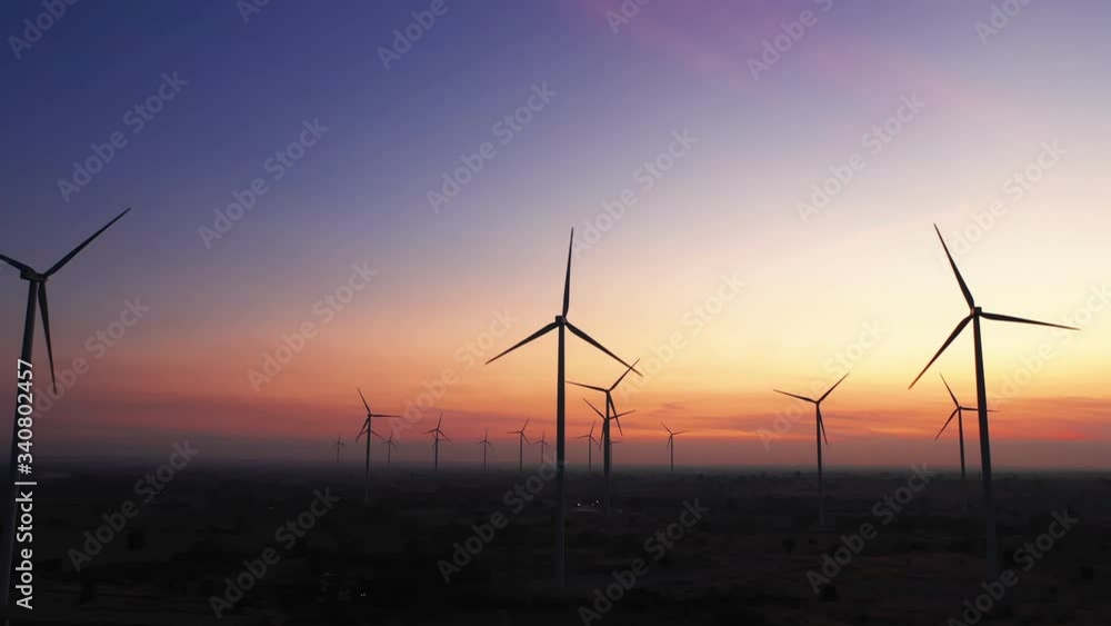 Aerial view of Wind turbines of save Energy save world in video 4k format. aerial shot on sunset. drone footage wind turbines at sunrise with beautiful clouds. Global warming concept and green energy. Aerial view of Wind turbines of save Energy save world in video 4k format. aerial shot on sunset. drone footage wind turbines at sunrise with beautiful clouds. Global warming concept and green energy.