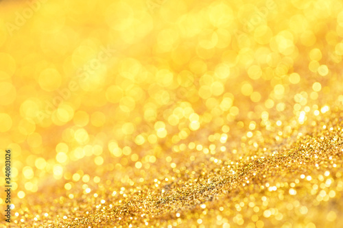 Gold glitter texture. Sparkling gold bright bokeh from blurred diamond dust. Abstract golden bokeh background. Selective focused