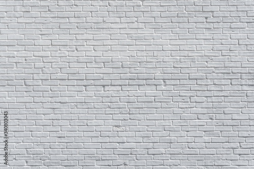 Brick painted white wall with delicate shadows, can be used for texture or background