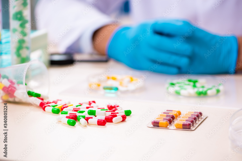 Young male chemist in drug synthesis concept Young male chemist in drug synthesis concept