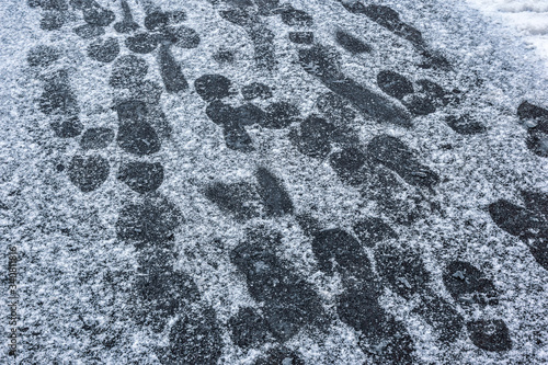 Obraz na płótnie many footprints on shoes on asphalt pavement covered with snow w salonie