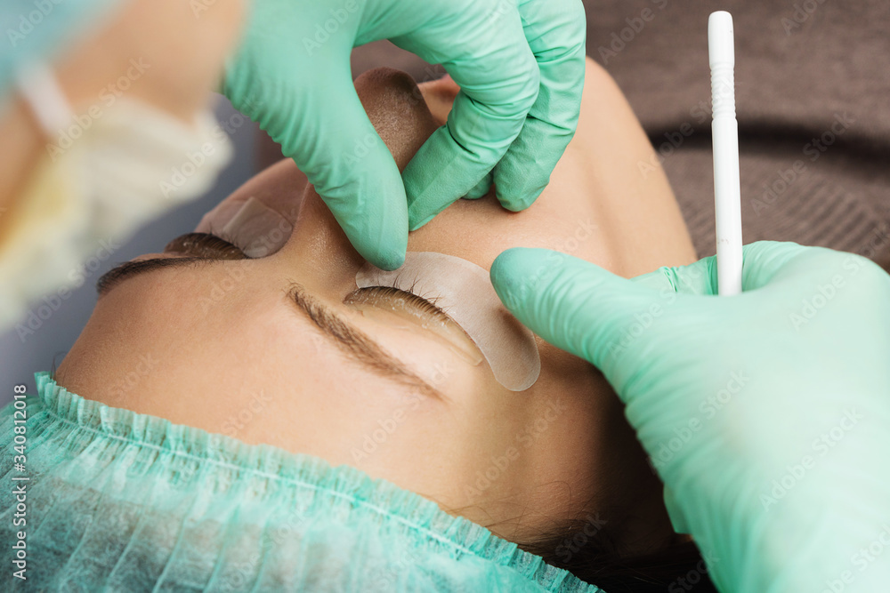 Young woman undergoing procedure of eyelashes lamination in beauty salon. Spa and Wellness. Close up. Perfect layout Young woman undergoing procedure of eyelashes lamination in beauty salon. Spa and Wellness. Close up. Perfect layout