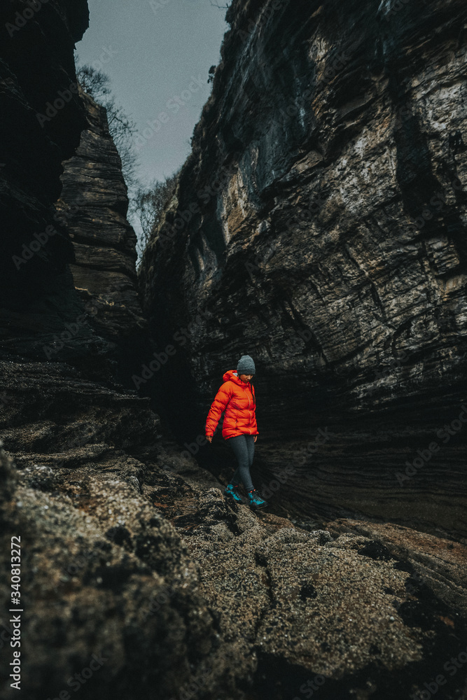 Hiker surrounded by dark cliffs