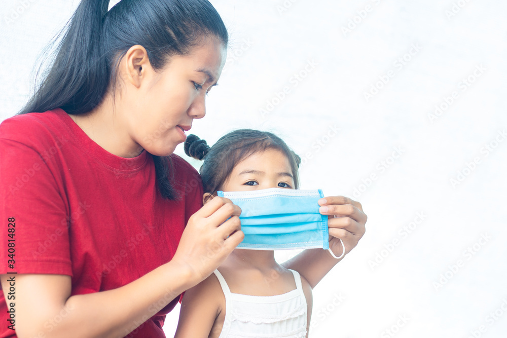 The mother wears a doctor's mask for her daughter to prevent the coronary virus that is spreading throughout the world and can also prevent other bacteria from entering the body The mother wears a doctor's mask for her daughter to prevent the coronary virus that is spreading throughout the world and can also prevent other bacteria from entering the body