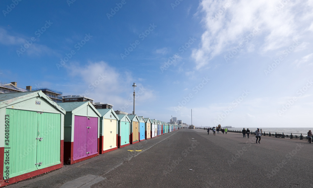People exercising on Hove seafront near Brighton, UK, with colourful beach huts People exercising on Hove seafront near Brighton, UK, with colourful beach huts