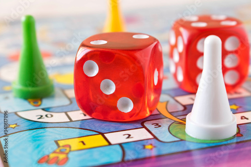 Multi-colored game chips with dice on the playing board. Concept of leisure games .