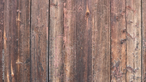 pink-brown wood of old untreated boards in the fence structure