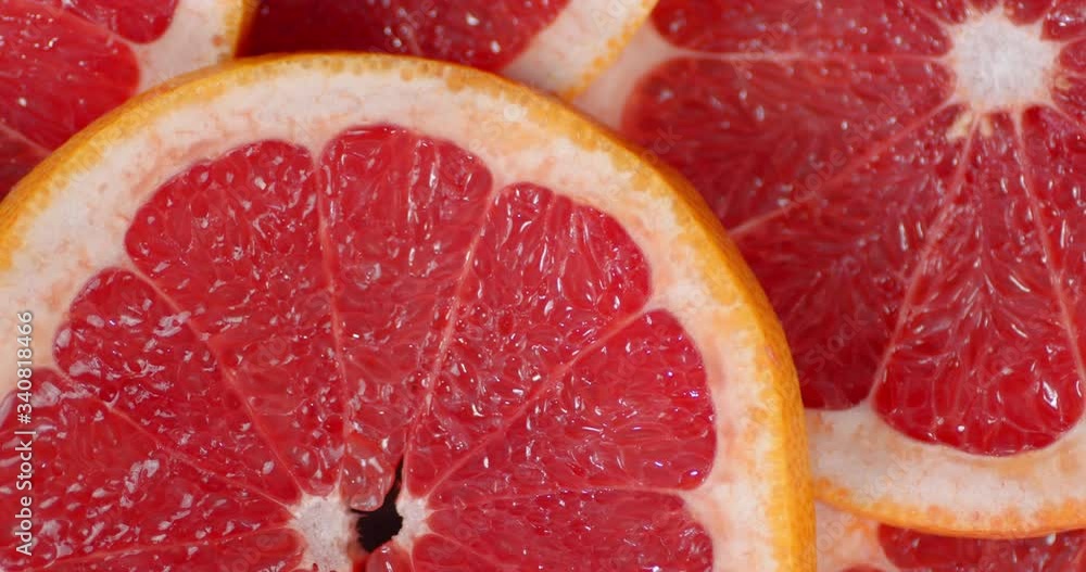 Round slices of fresh grapefruit slowly rotate. Round slices of fresh grapefruit slowly rotate.