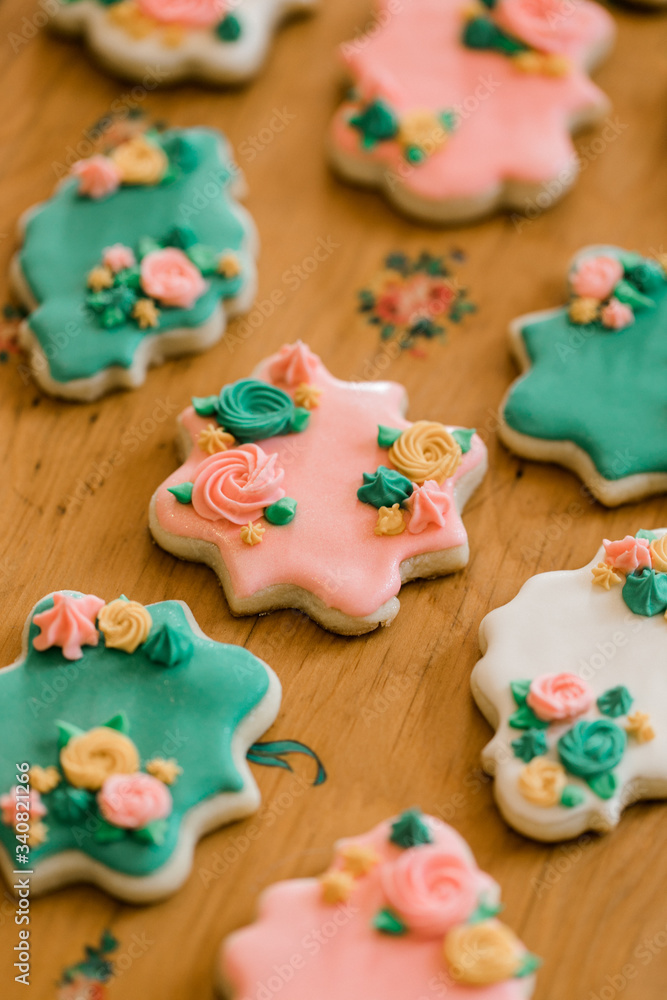 A tray of multi-colored vanilla cookies decorated with cream flowers