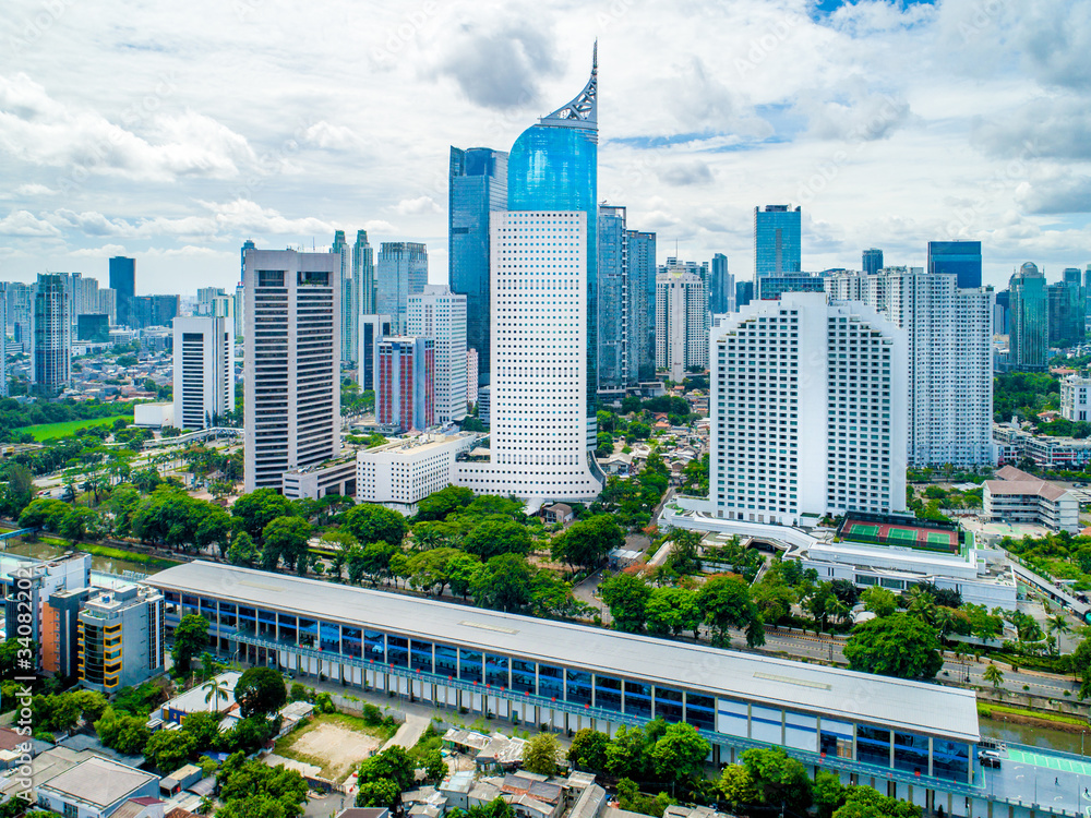 Aerial View of Jakarta Downtown Skyline with High-Rise Buildings With White Clouds and Blue Sky, Indonesia, Asia Aerial View of Jakarta Downtown Skyline with High-Rise Buildings With White Clouds and Blue Sky, Indonesia, Asia