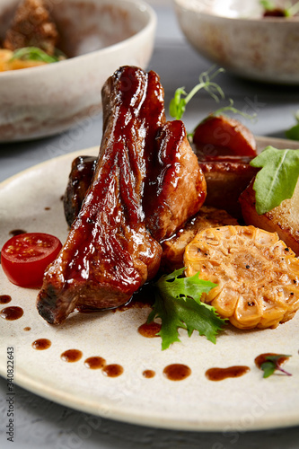 Baked ribs with homemade potatoes and coleslaw salad in white plate