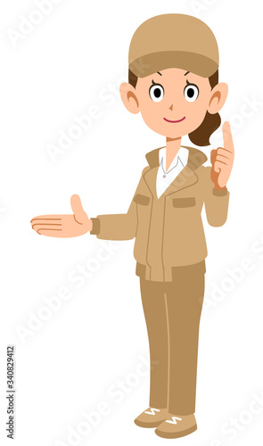 右側を紹介し人差し指を建てるベージュ色の作業着を着た女性
