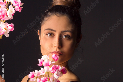 Fototapeta Naklejka Na Ścianę i Meble -  Gorgeous young girl with colorful flowers, studio portrait