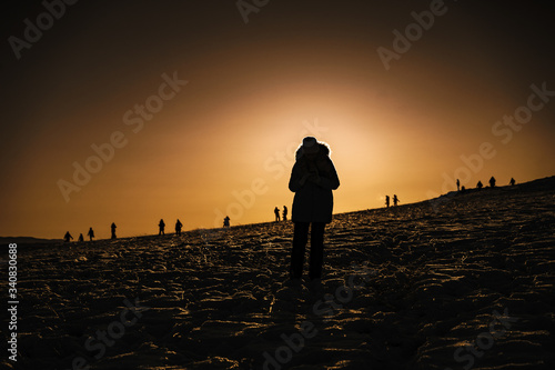 silhouette of a man walking on the beach at sunset