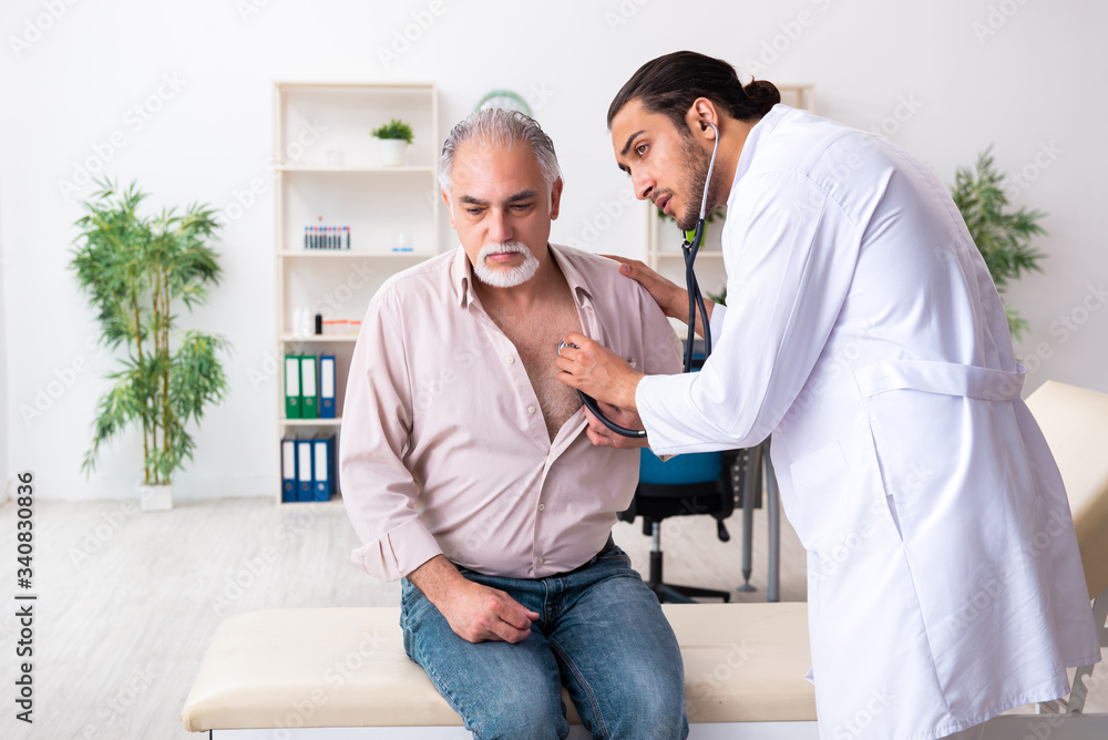 Fototapeta premium Old man visiting young male doctor cardiologist