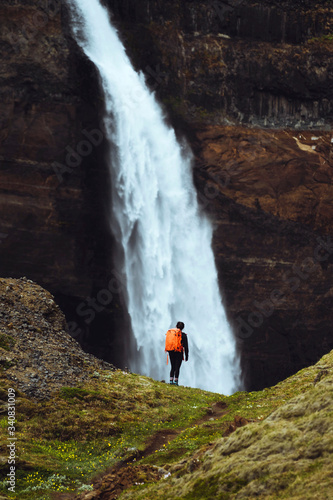 Traveler by a waterfall