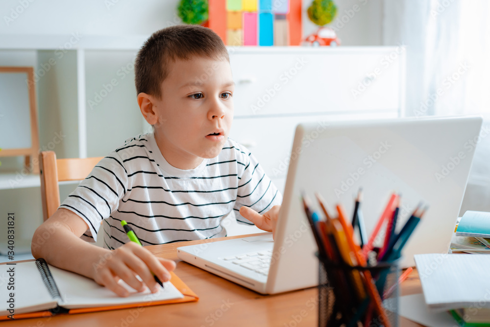 Distance learning online education. A schoolboy boy studies at home and does school homework. A home distance learning Distance learning online education. A schoolboy boy studies at home and does school homework. A home distance learning