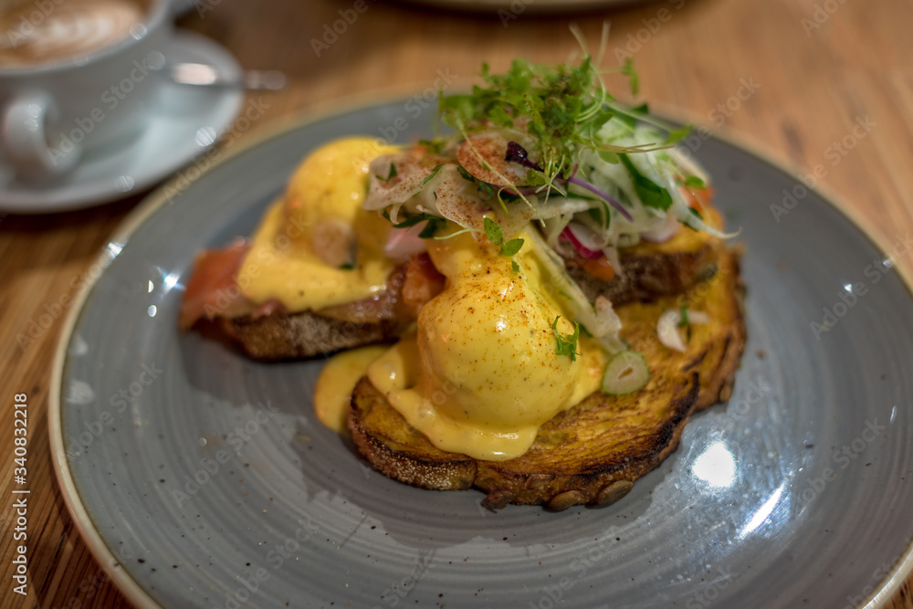 Eggs benedict on sourdough toast with greens, pesto and mushrooms Eggs benedict on sourdough toast with greens, pesto and mushrooms