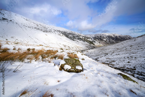 Photography A snow covered Glenridding Beck below Catstye Cam with Glenridding Screes in the distance on a sunny winters day in the Lake District, UK