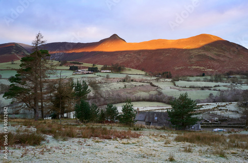 A frost covered valley of Newlands with a winters sunrise catching the mountain top of Causey Pike, Derwent Fells in the Lake District.