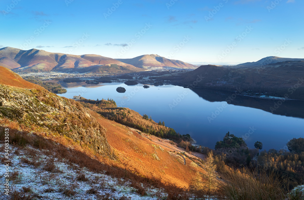 Sunrise over Derwent Water near Keswick with the summits of Skiddaw and Blencathra in the distance from below Maiden Moor on a cold winters morning in the Lake District.