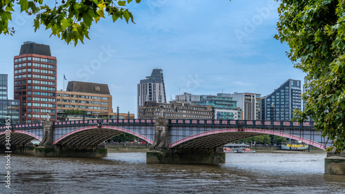 View of Lambeth bridge and city buildings along the River Thames in London photo