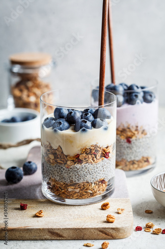 Breakfast parfait with chia, granola, berries and yogurt in a glass. Layer dessert in glass.