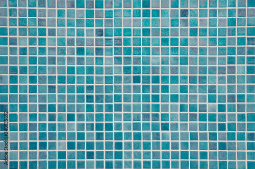 Aqua blue swimming pool mosaic tiles background, textured pool walls with copy space, a summer vacation inspiration, traveling to a tropical destination or relaxing holidays atmosphere concepts © Ana