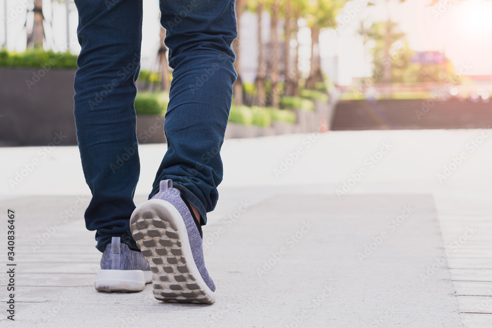 close up legs of young businessman while walking forward in the modern city with the sunspot background. Go up, success, grow up concept. close up legs of young businessman while walking forward in the modern city with the sunspot background. Go up, success, grow up concept.