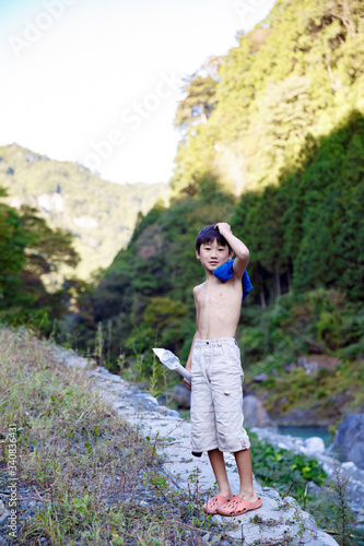 川原で上半身裸の少年 photo