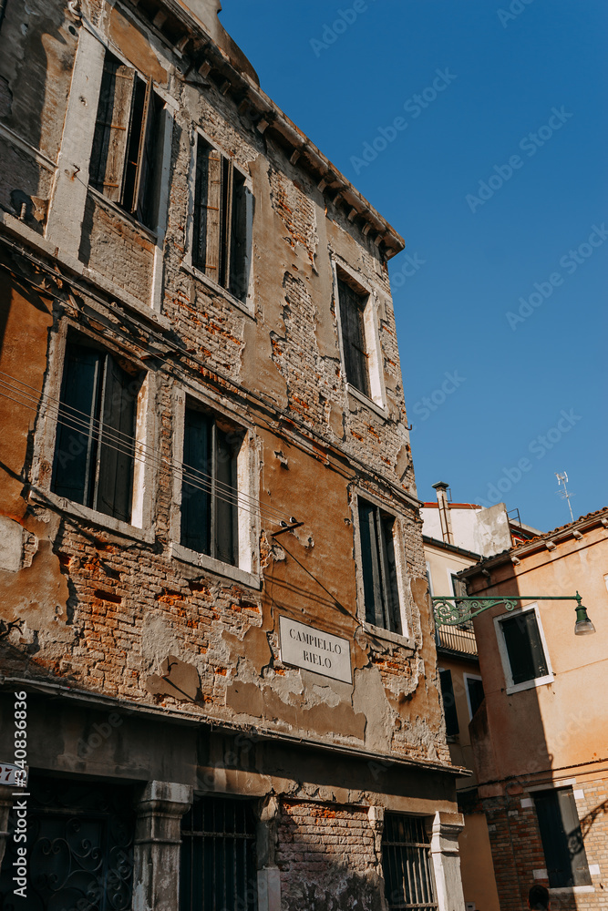 An old building with a textured wall in Venice on a clear day against a blue sky | VENICE, ITALY - 16 SEPTEMBER 2018. 