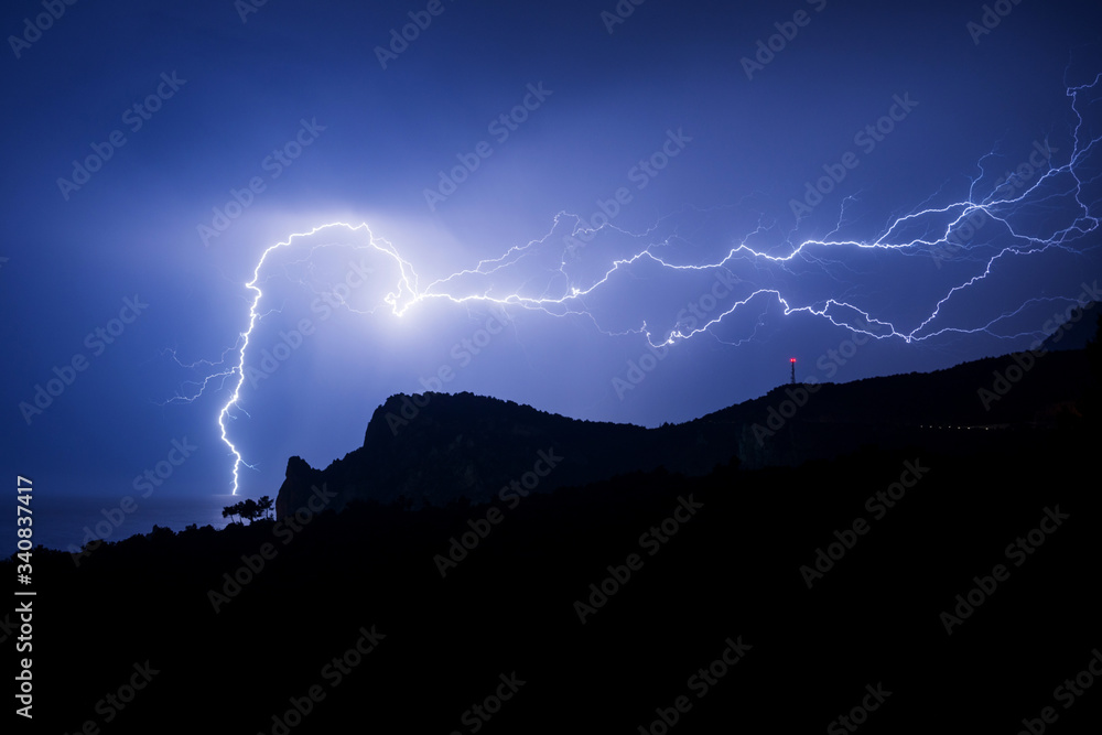 Powerful lightning over a rock on the Black sea coast