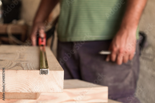 Male carpenter working on old wood in a retro vintage workshop.