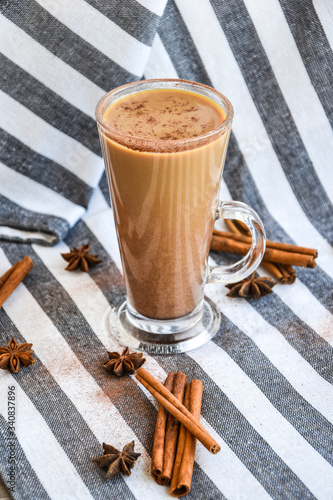 Delicious iced coffee and milk melt drink, cinnamon sticks and anise stars on gray cloth, latte or machiato photo