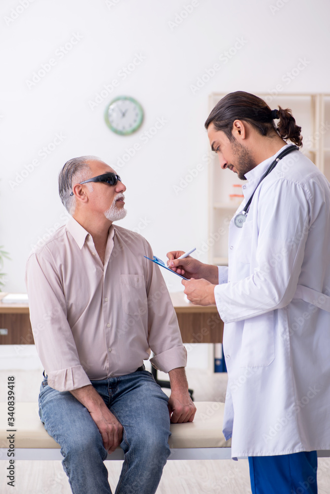 Fototapeta premium Old blind man visiting young male doctor