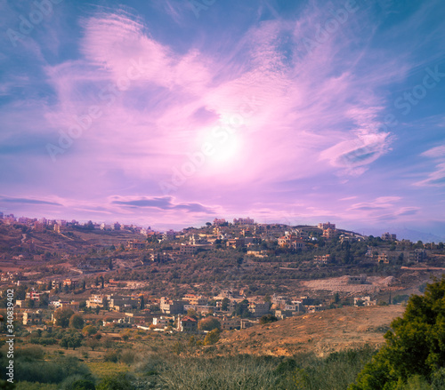 Urban landscape with beautiful evening sky. Panoramic view of small town on mount at sunset. Lebanon, Western Asia