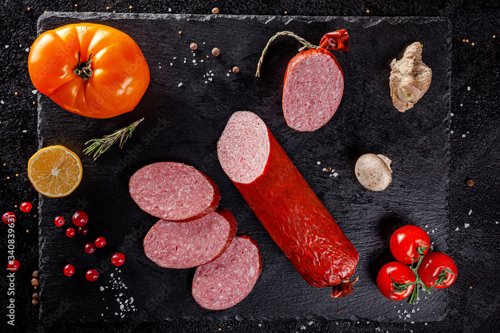 Various sausages and smoked products lie on a black board, sausage, sausages, ribs, rolls. Top view, overhead. Flat lay Various sausages and smoked products lie on a black board, sausage, sausages, ribs, rolls. Top view, overhead. Flat lay