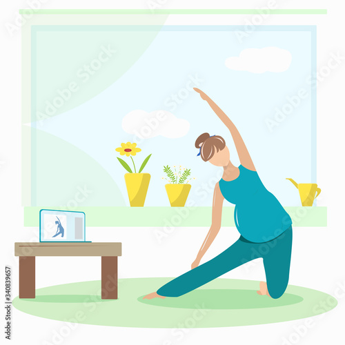 Pregnant girl is engaged in yoga in the lessons on the laptop
