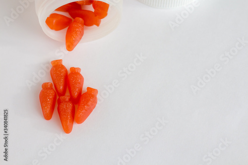 Obraz na plátně orange gummy vitamins like carrots ( carotene supplement ) on white background t