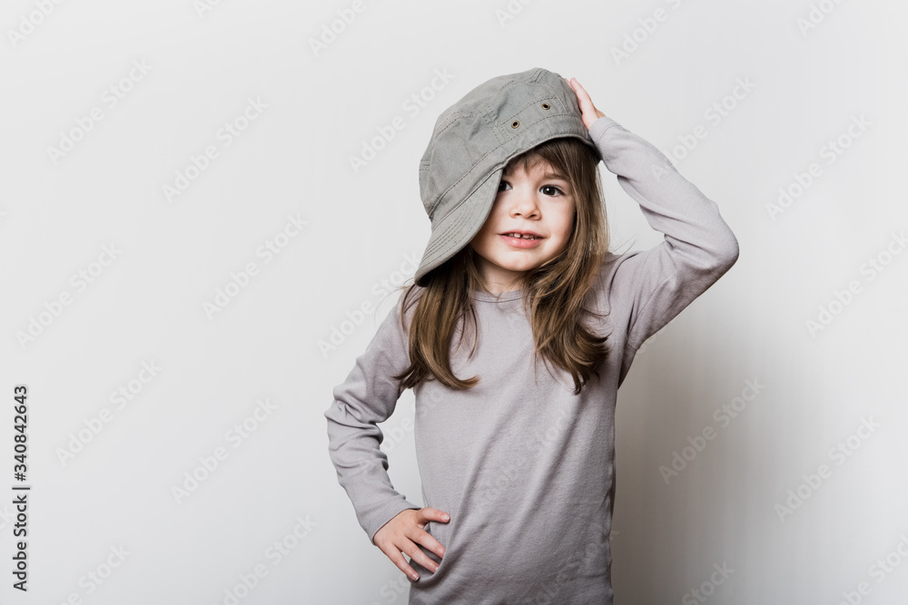Une petite fille avec une casquette trop grande pour sa tête Photos | Adobe  Stock